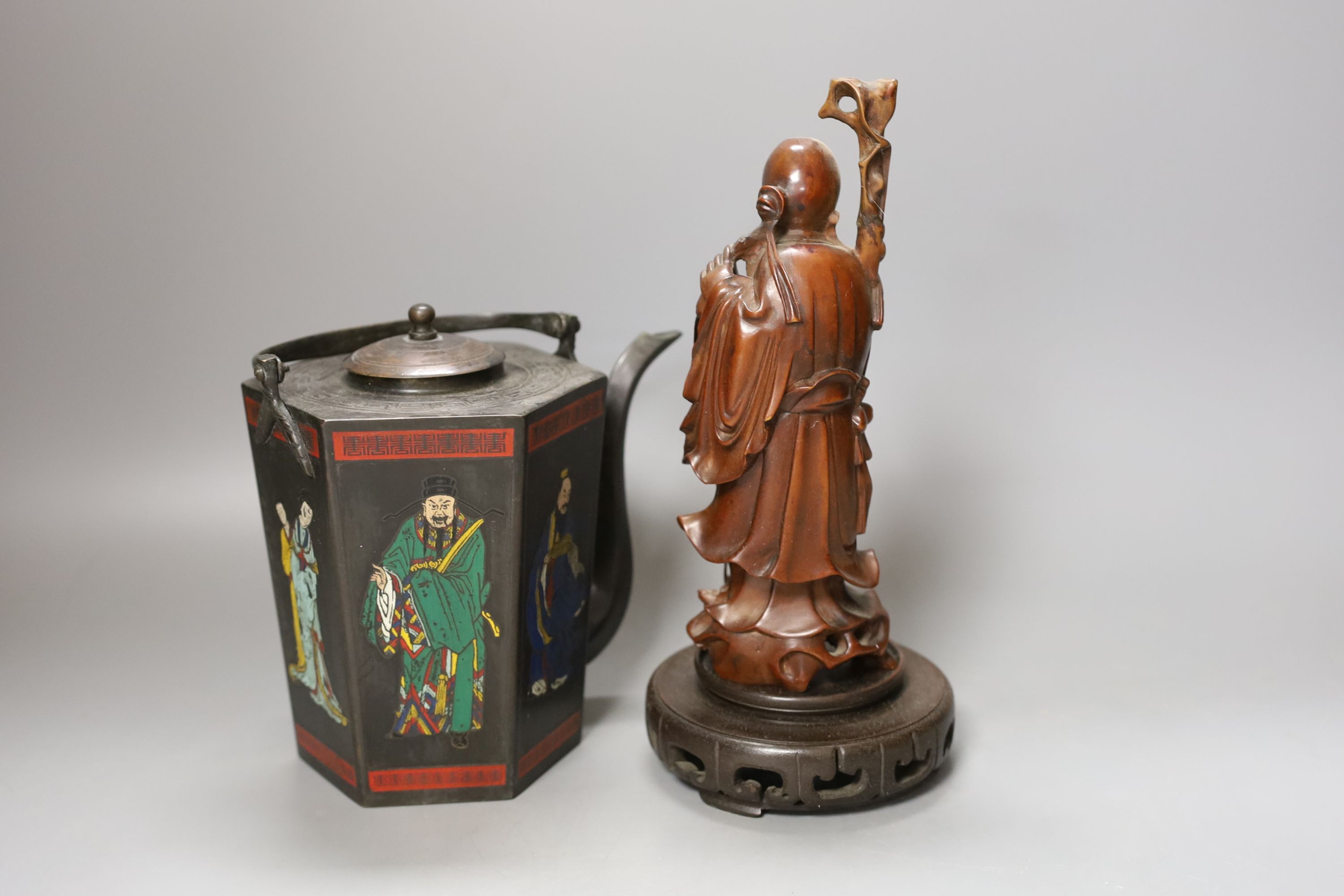 A Chinese carved hardwood figure of Shao Lao on hardwood stand and a similar painted metal teapot, figure 24cm including stand